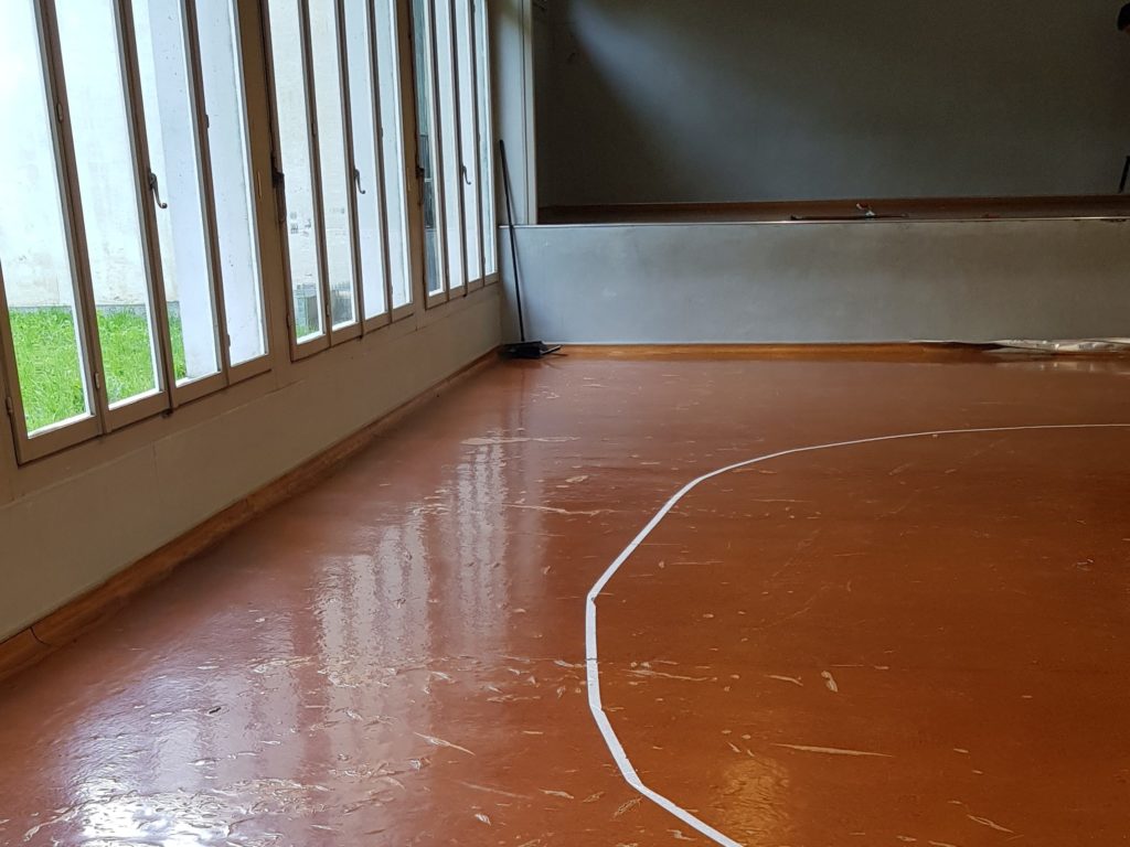 Ancien lino-liège abîmé et écaillé dans une salle de rythmique scolaire