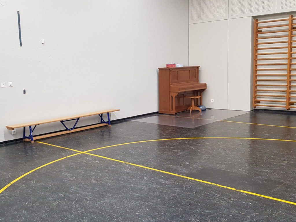 Ancien lino-liège foncé avec un marquage jaune dans une salle de rythmique