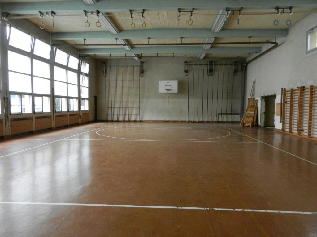 Ancien lino-liège brun aux lignes usées dans une salle de gymnastique scolaire