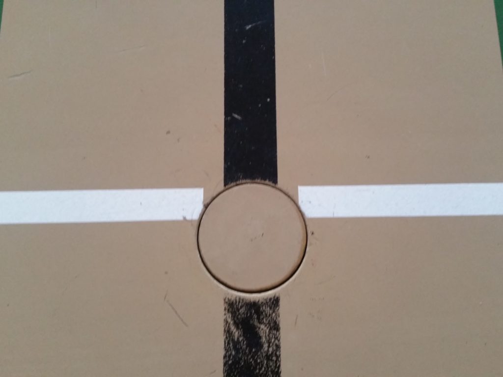 Ancienne douille d'engin au croisement de deux lignes de jeu, couvercle rond d'origine avec du jeu sur son pourtour