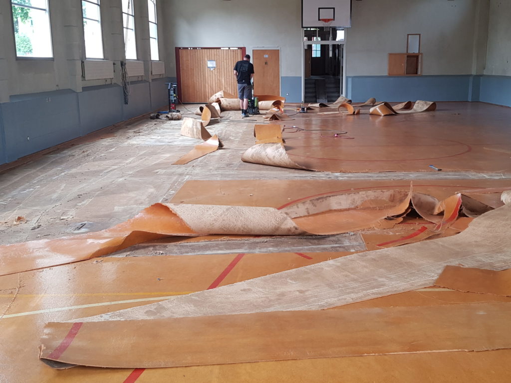 Arrachage de l'ancien lino-liège dans une salle de gymnastique