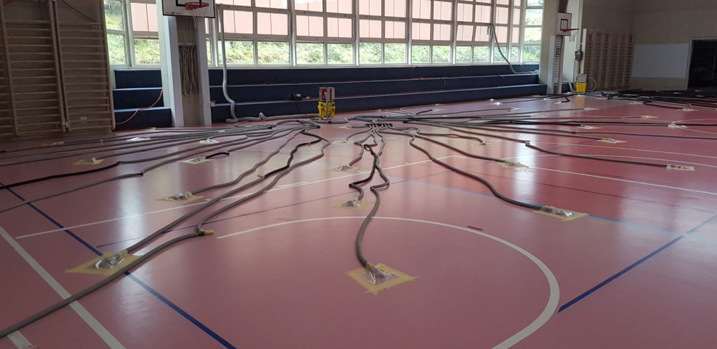 Salle de sport en cours d'assèchement, des dizaines de gaines raccordées aux carottages du sol