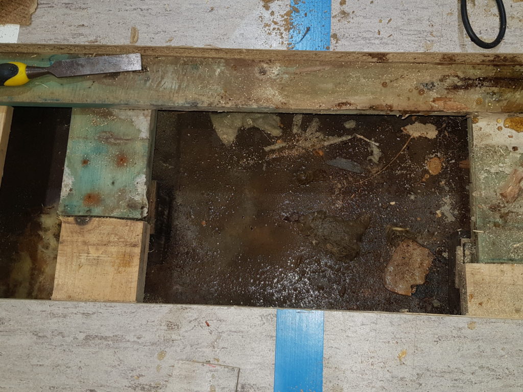 Plancher sportif ouvert, dalle mouillée, cales de mise à niveau dégradées et isolation détrempée sous la sous-construction