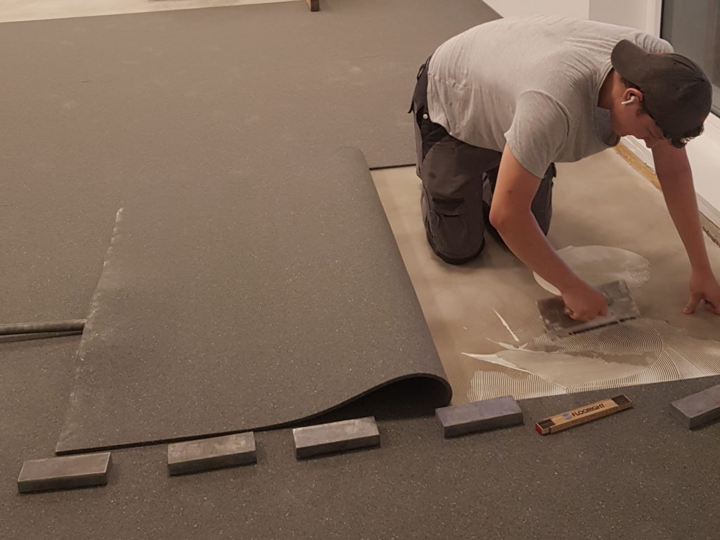 Collage des lés de sous-couche souple dans une salle de rythmique