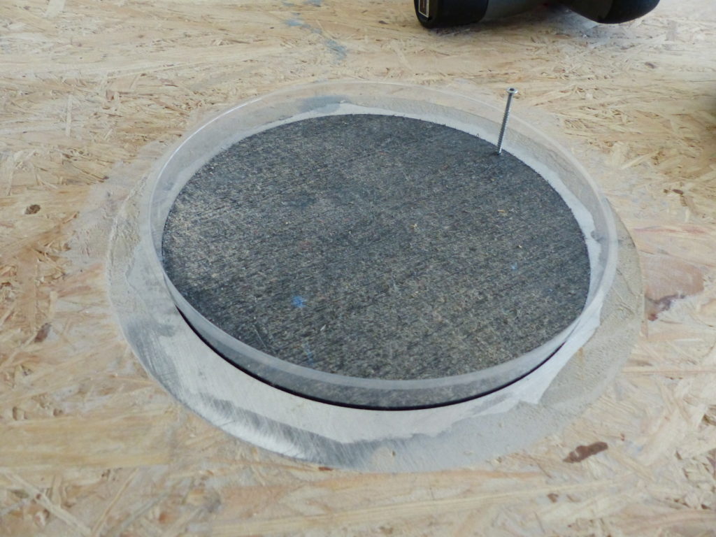 Douille de sol encastrée dans un plancher en panneaux OSB avant la pose du revêtement