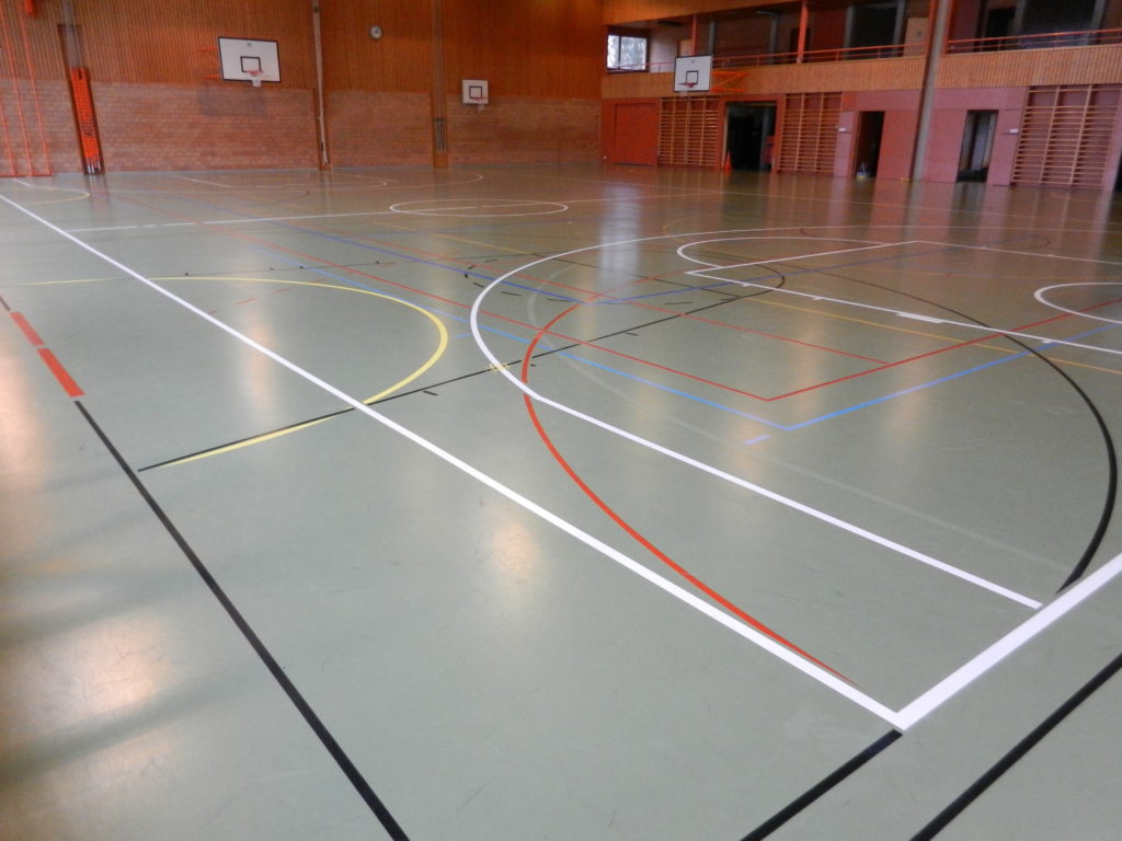 Nouveau marquage de basket en blanc dans une salle de sport au sol vert