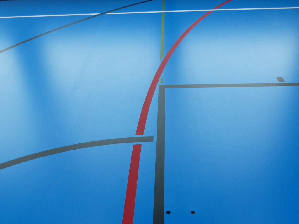 Détail du marquage des lignes de jeu sur un sol sportif en résine bleu ciel