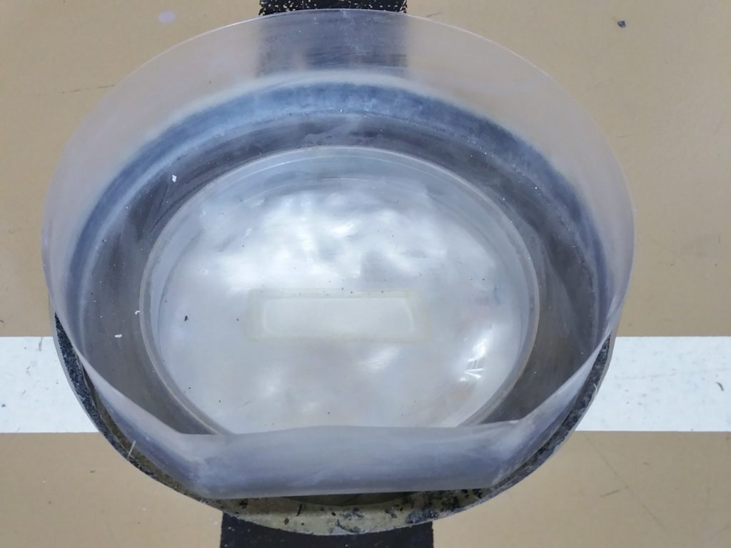 Moule transparent posé sur une nouvelle douille de sol sportif, résine coulée pour fabriquer un couvercle sur mesure