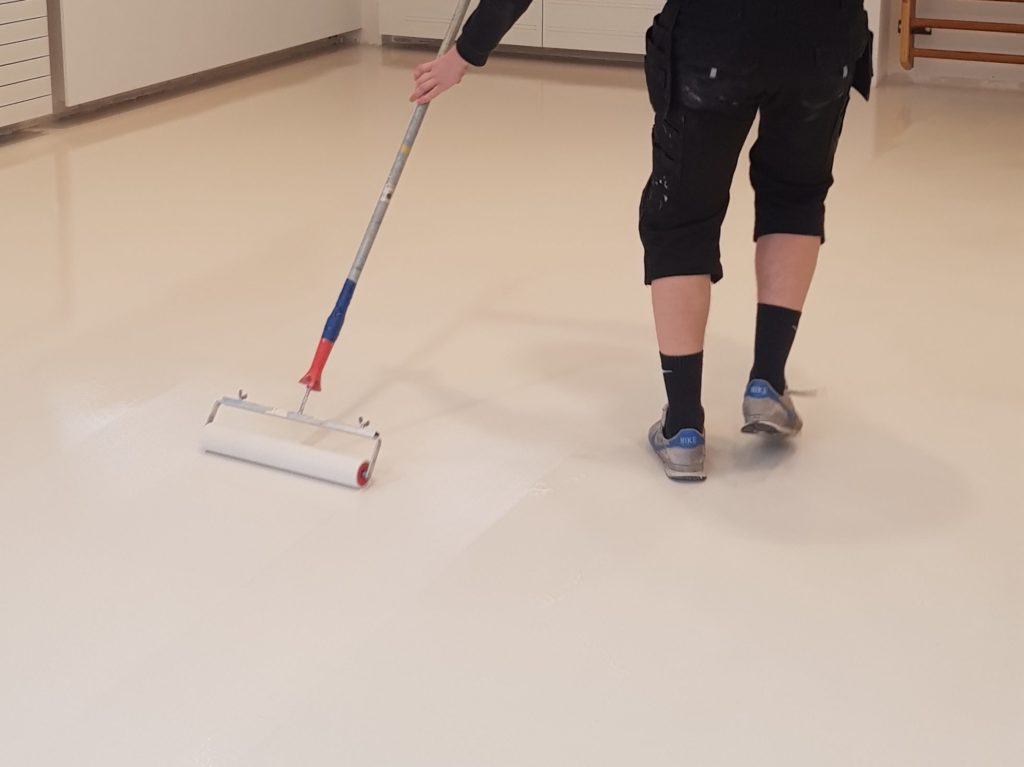 Application de la peinture de sol au rouleau sur la résine polyuréthane