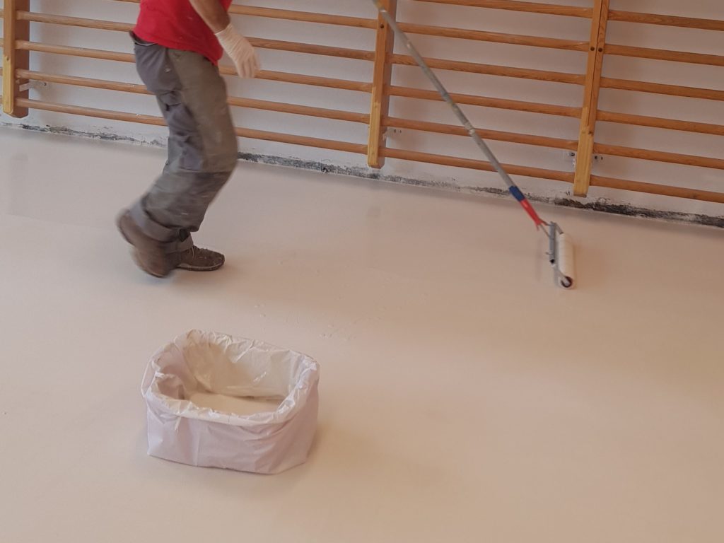 Application de la peinture de sol au rouleau le long des espaliers