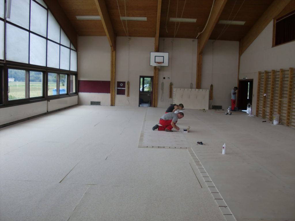Pose des panneaux d'un plancher sportif directement sur l'ancien linoléum d'une salle polyvalente