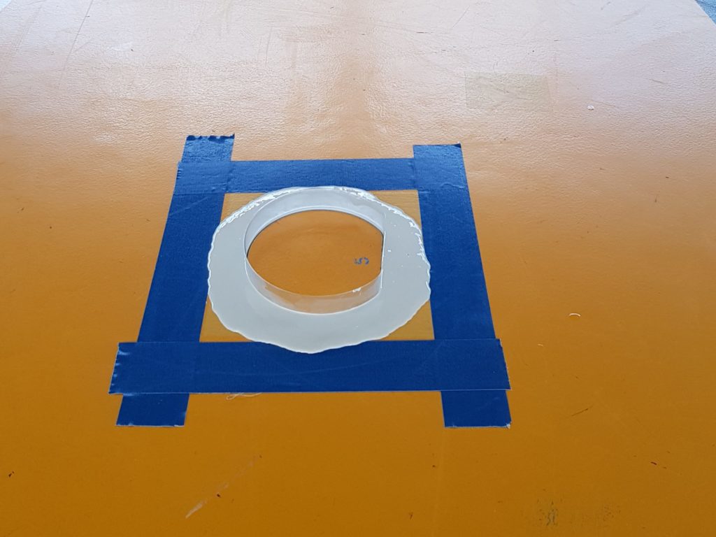 Rangée de douilles dans une salle de gymnastique, nouveaux pourtours en résine coulés dans leur moule et cadrés au ruban