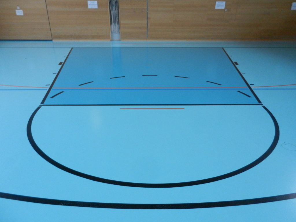 Raquette de basket sur un sol sportif bicolore avant la mise en conformité aux normes FIBA