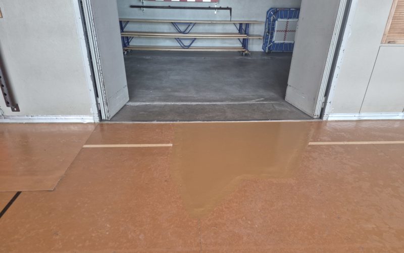 Zone réparée recouverte d'une peinture deux composants dans la teinte du lino-liège existant, devant un local à engins