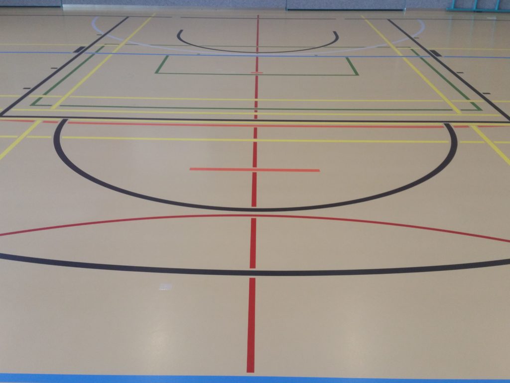 Salle de sport après marquage, terrain de unihockey et lignes scolaires intégrés au tracé existant