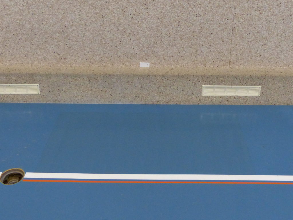Sol sportif terminé le long d'un mur de salle de sport, zone reconstruite sans trace visible