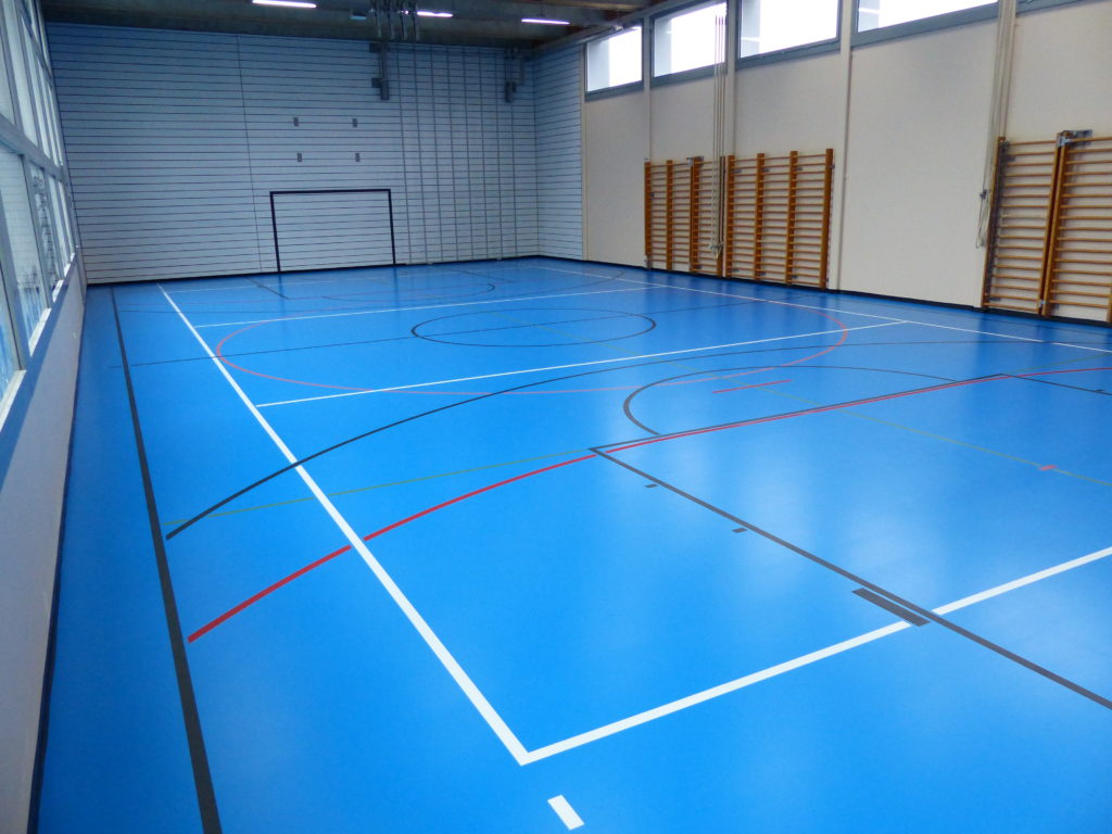 Salle de sport avec un nouveau sol en résine polyuréthane bleu ciel et marquage multisport