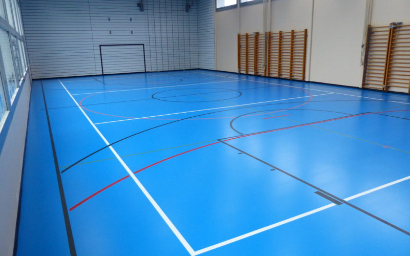 Salle de sport avec un nouveau sol en résine polyuréthane bleu ciel et marquage multisport