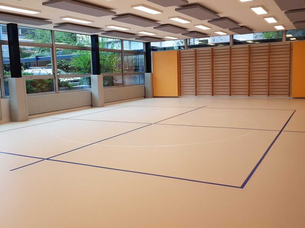 Salle de rythmique avec un nouveau sol sportif en résine clair et un marquage bleu et blanc