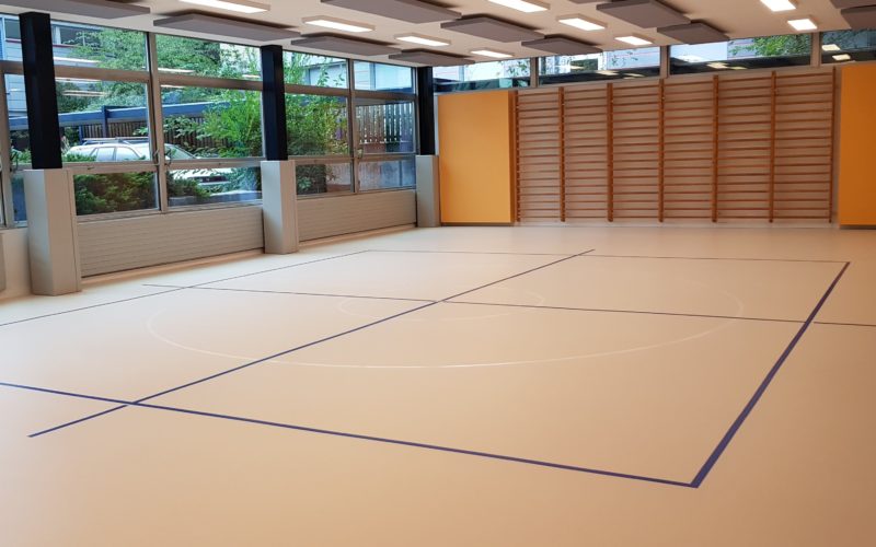 Salle de rythmique avec un nouveau sol sportif en résine clair et un marquage bleu et blanc