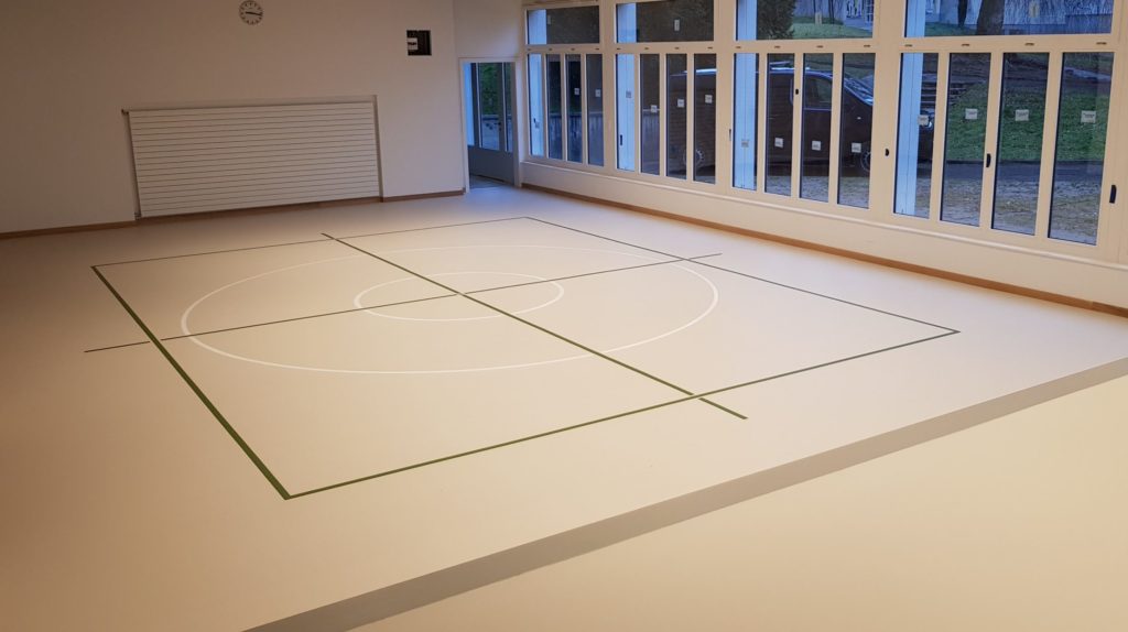 Salle de rythmique avec un nouveau sol sportif sans joint en résine et un marquage vert et blanc