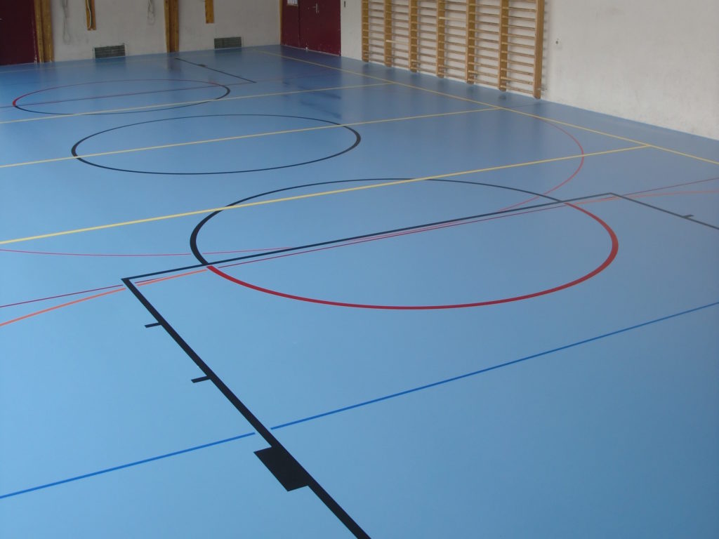 Salle polyvalente avec un nouveau sol sportif bleu à souplesse combinée et un marquage multisport