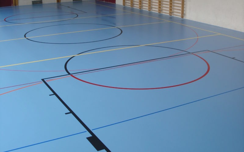 Salle polyvalente avec un nouveau sol sportif bleu à souplesse combinée et un marquage multisport
