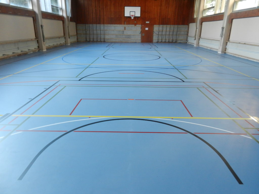 Salle de sport avec un nouveau sol sportif bleu à souplesse ponctuelle et un marquage multisport
