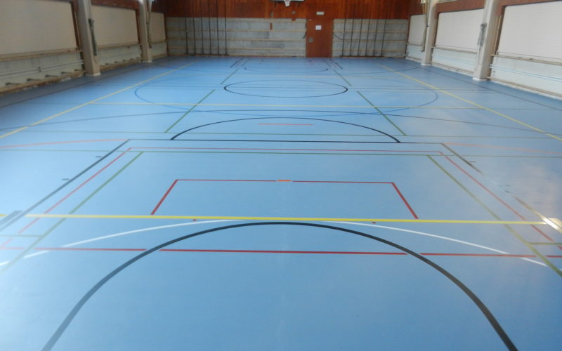 Salle de sport avec un nouveau sol sportif bleu à souplesse ponctuelle et un marquage multisport