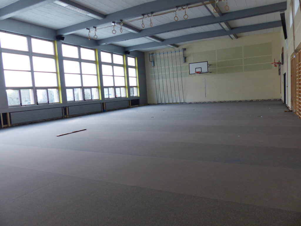 Sous-couche souple grise posée sur le plancher de toute la salle de gymnastique