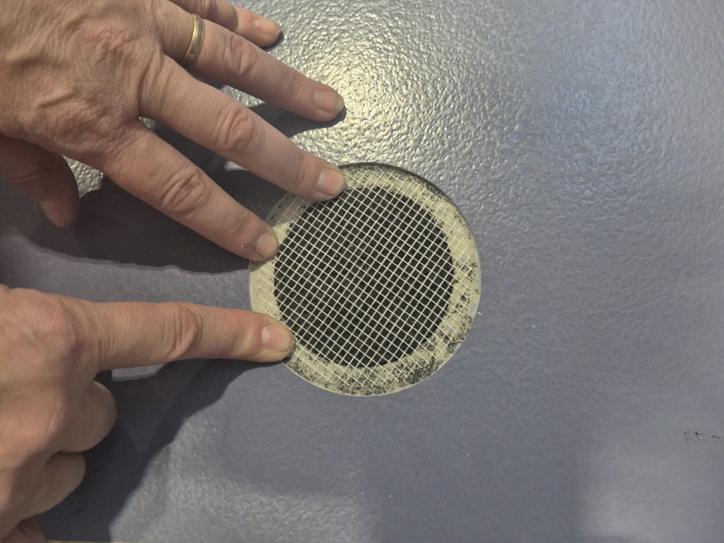 Percement refermé dans un sol sportif : plancher refait, sous-couche rebouchée et filet de renforcement collé avant la finition