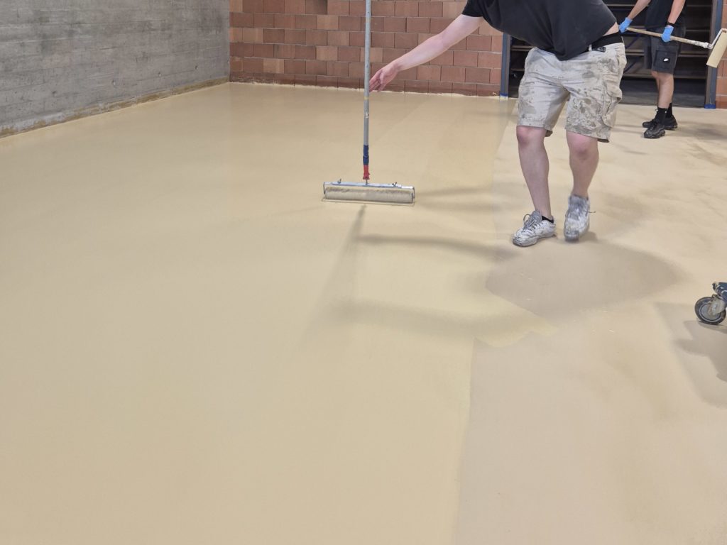 Application de la peinture de finition au rouleau sur le sol sportif ProtecSport SP 40 d'une salle de rythmique