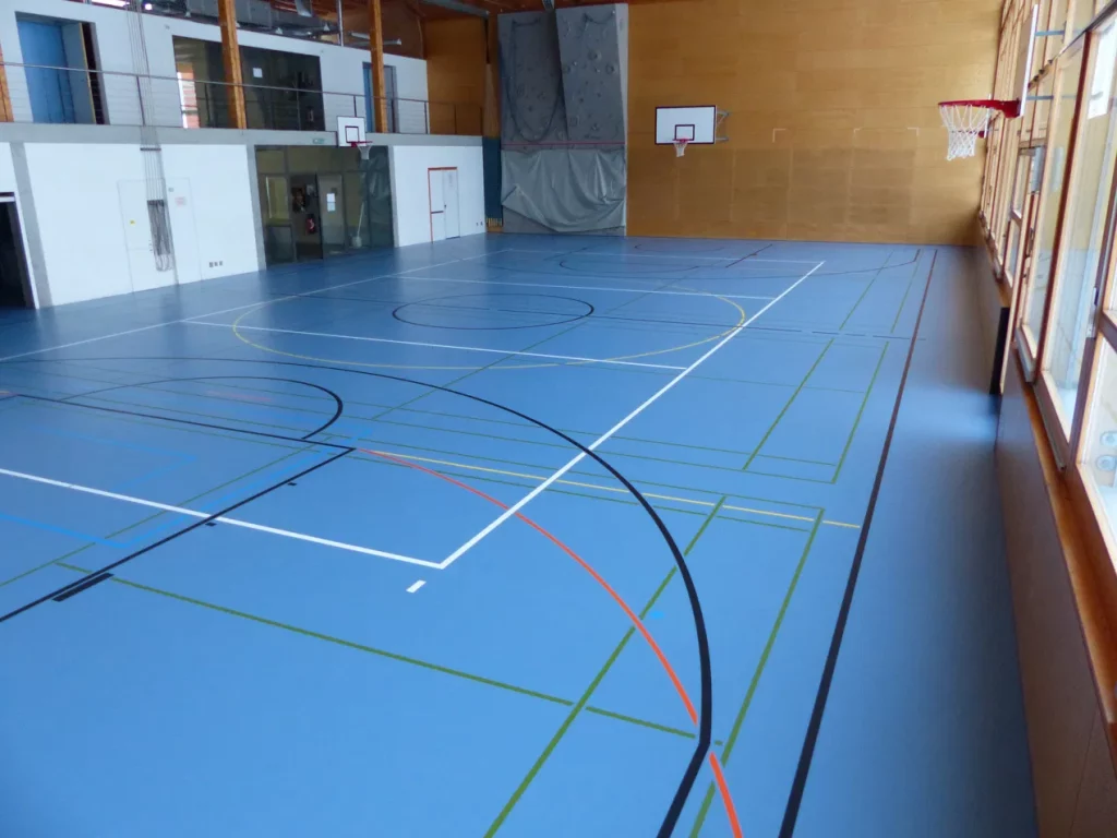 Salle de gymnastique au sol en résine bleu rénové et au marquage multisport refait