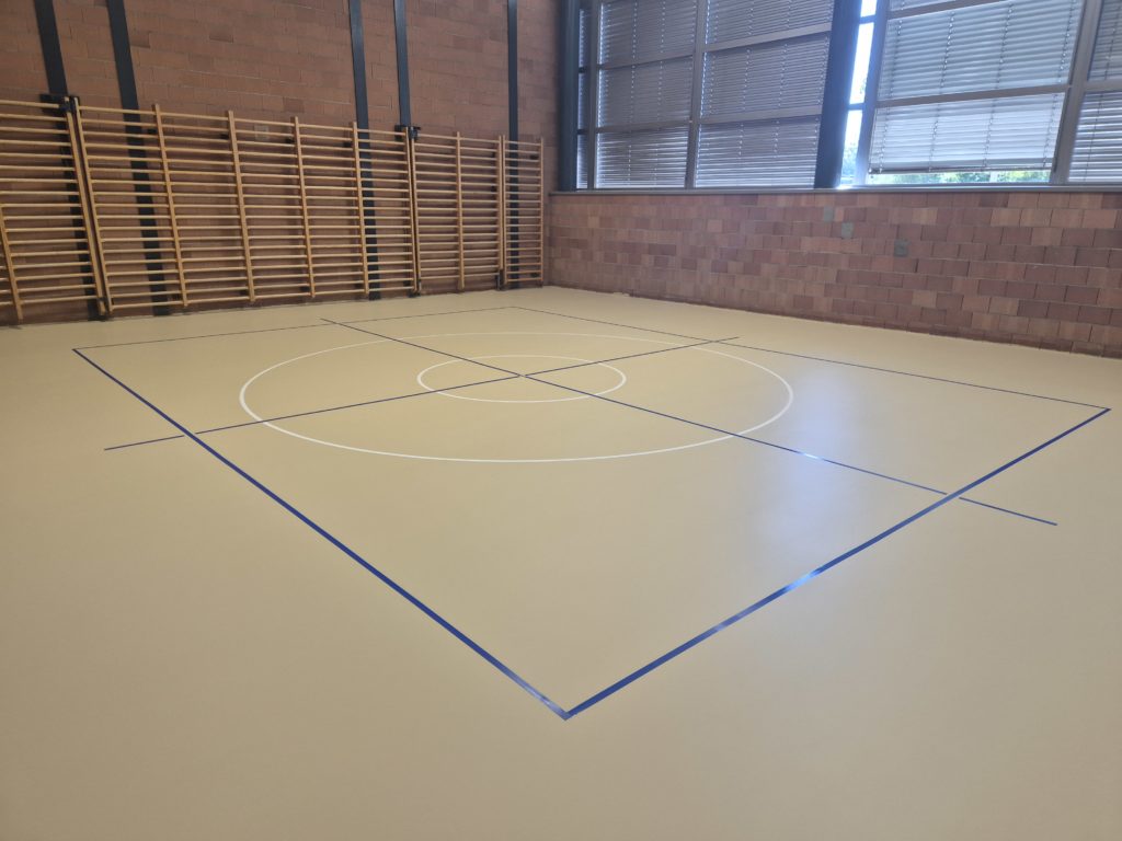 Salle de rythmique avec un nouveau sol sportif ProtecSport SP 40 beige et un marquage adapté à l'enseignement : carré bleu, croix et cercles blancs